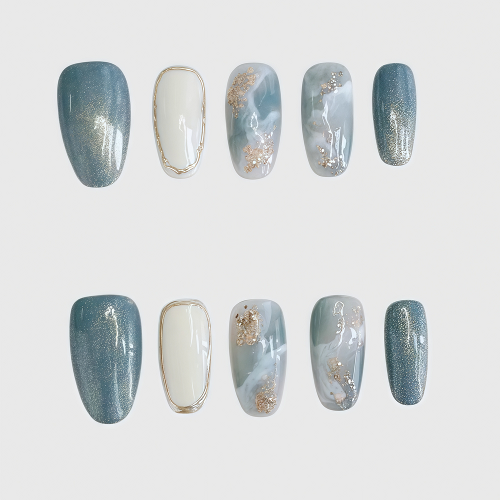 Round press-on nails with blue marble pattern, white accent nails, and gold foil decoration, combining elegance and simplicity for a refined nail look.