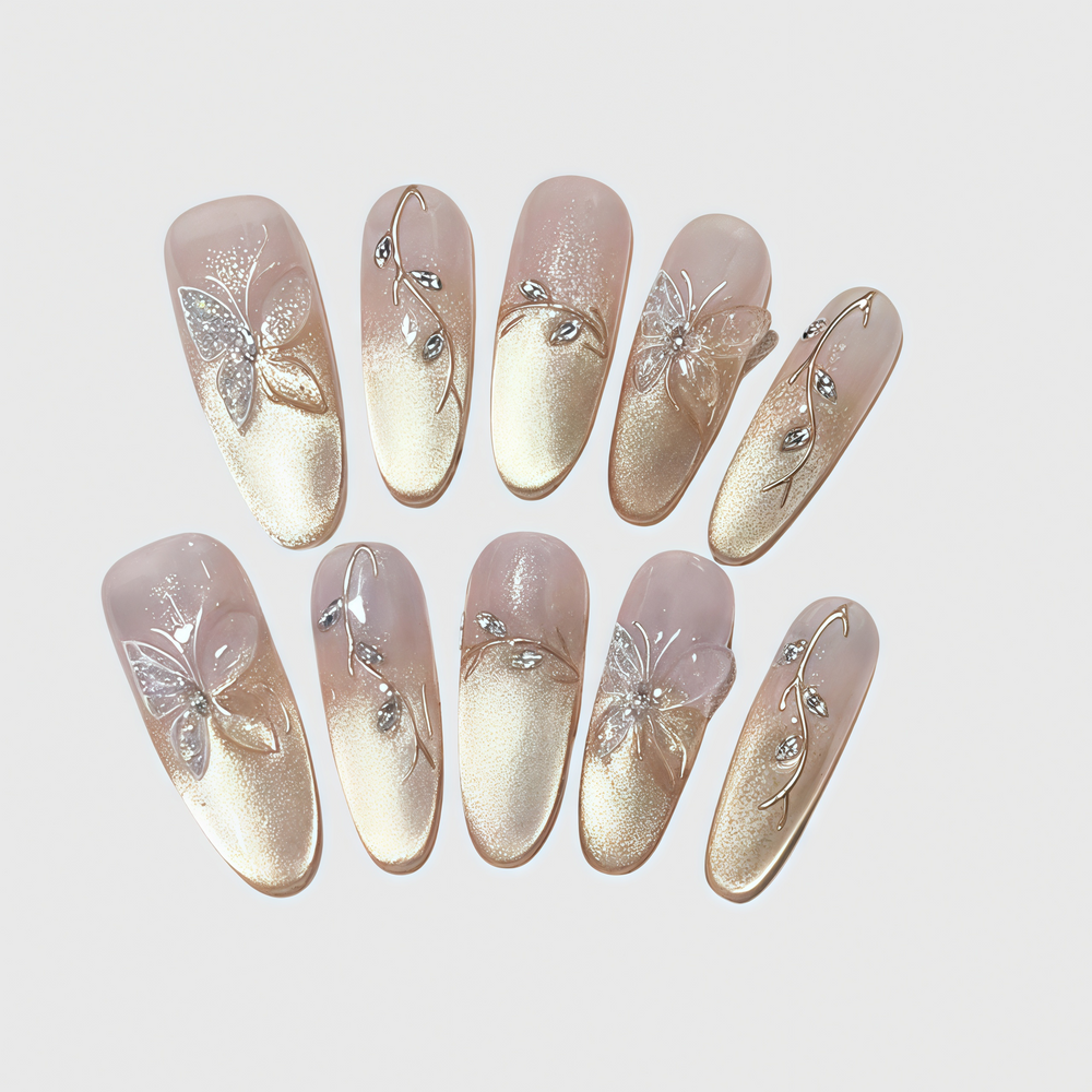 Almond-shaped press-on nails with gold gradient finish, 3D butterfly decorations, and crystal vines.