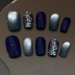 Square press on nails with dark blue cat eye shimmer and galaxy glitter, short length.