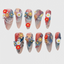 Stiletto press on nails with 3D flowers, pearls, and red-blue gradient design for elegant nail art look