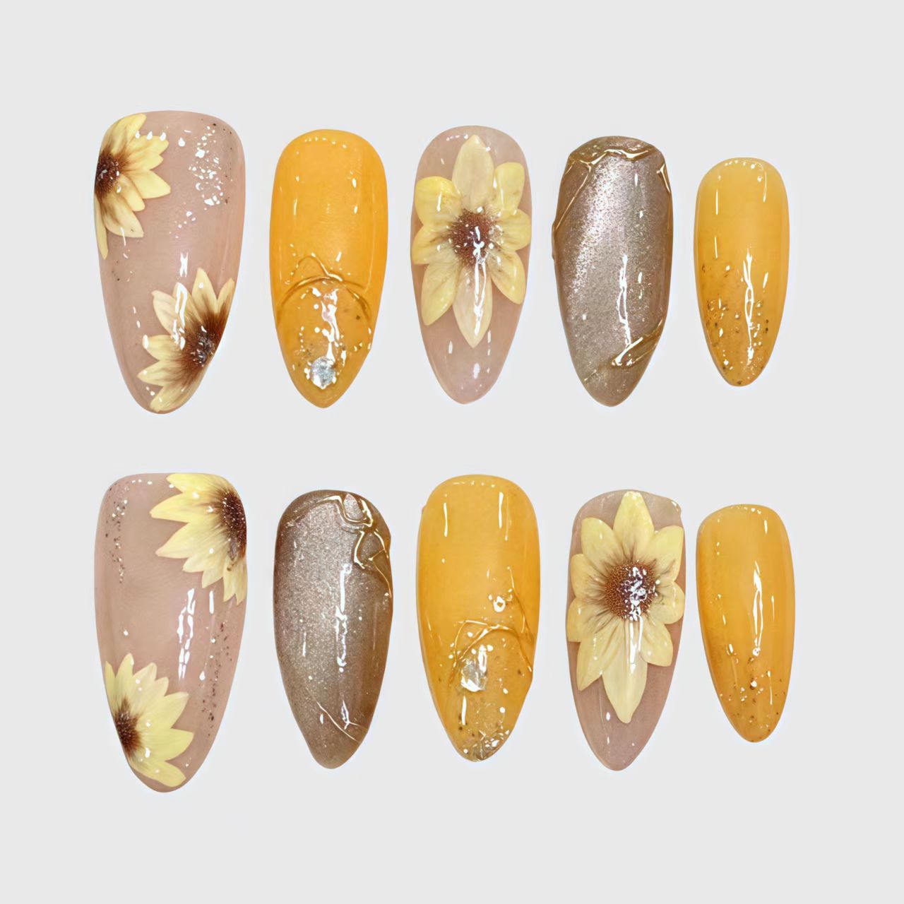 Almond-shaped press-on nails with hand-painted 3D sunflower designs, combining yellow, nude, and brown tones with glitter, gold foil, and transparent details for a warm autumn aesthetic. Main image