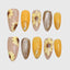 Almond-shaped press-on nails with hand-painted 3D sunflower designs, combining yellow, nude, and brown tones with glitter, gold foil, and transparent details for a warm autumn aesthetic.