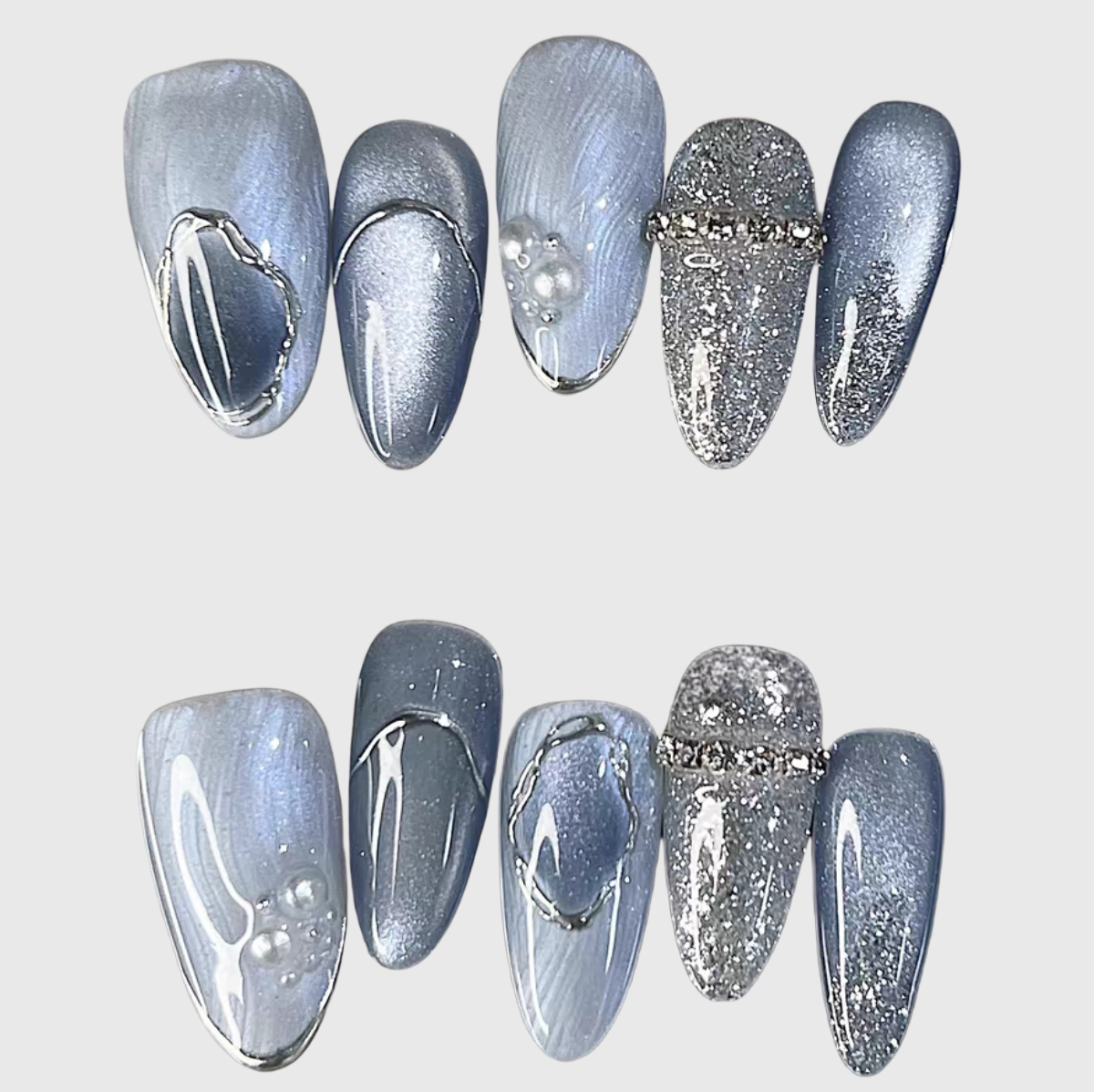 Blue oval press-on nails with cat eye effect, silver glitter, pearl and metal wave accents. Main image
