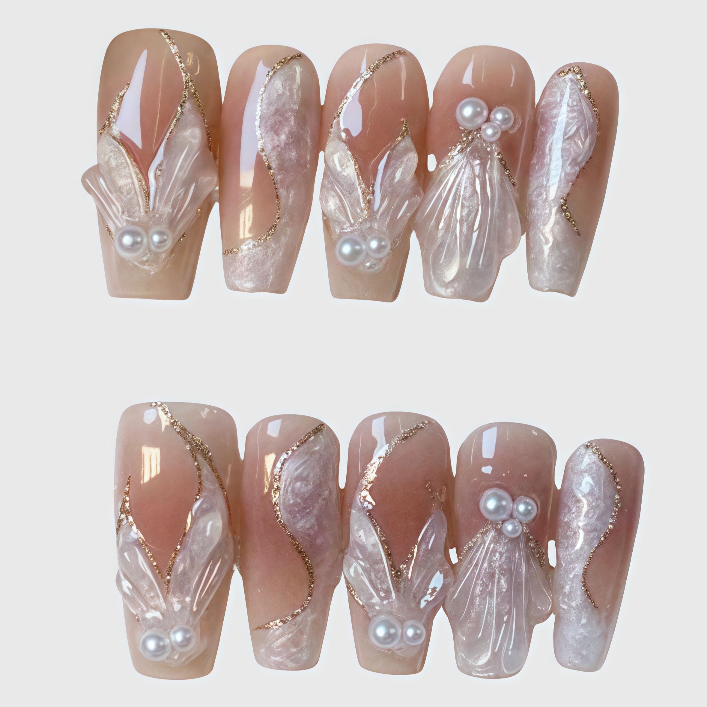 Coffin-shaped nude pink press-on nails with 3D shell and pearl designs, gold foil accents, and sculpted textures for a luxurious elegant look.

 Main image